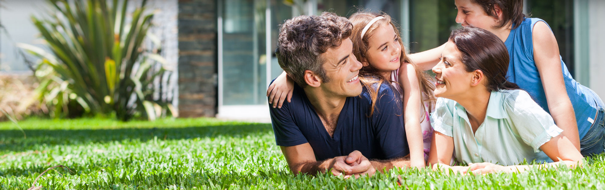 Man and daughter laying on grass